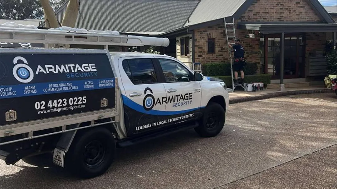 The Armitage Security ute at a Shoalhaven home, a technician on a ladder at the roofline