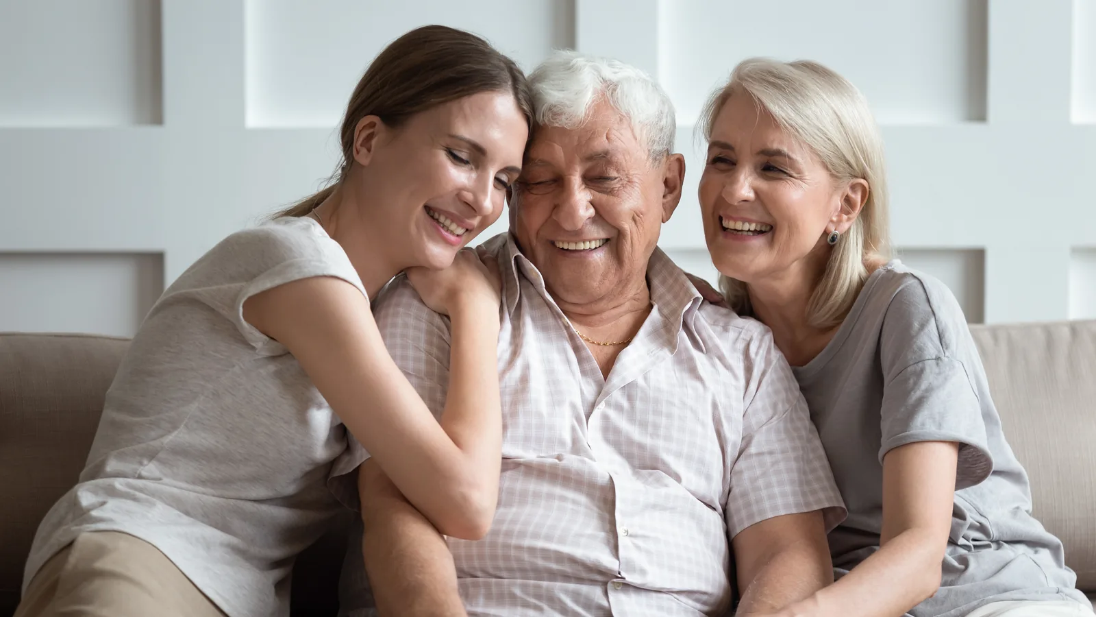 An older man at home with two younger women in his family