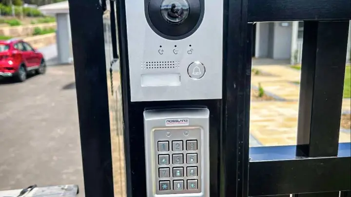 A video intercom and access control keypad mounted on a steel gate